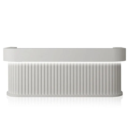 Front view of white curved reception desk with LED-lit fluted panel