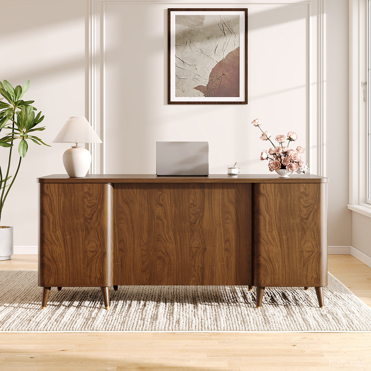 Wooden desk in a room with a plant, lamp, and framed picture on the wall.
