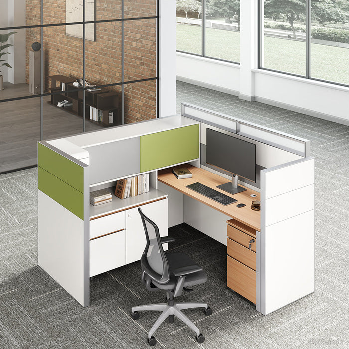 Modern office desk with green and white panels, computer setup, and chair in a bright room.
